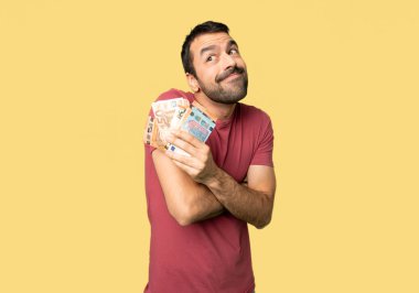 İnsan izole sarı arka planda omuzları kaldırırken şüphe jest yapma çok para alarak