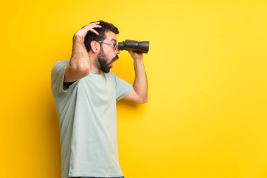 Adam sakallı ve yeşil gömlek ve Uzaktan dürbünle bakıyor