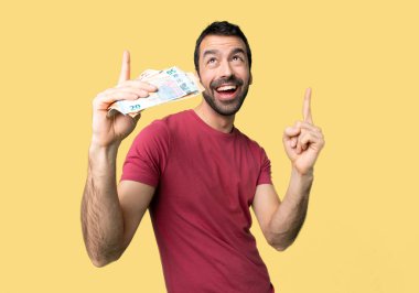 Adam işareti parmak ile izole sarı arka plan üzerinde büyük bir fikir işaret çok para alarak