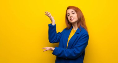 Yanına gelmek için davet için eller trençkot genişletme ile genç Kızıl saçlı kadın