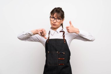 İyi-kötü işaret yapma önlük olan kadın. Arasında kararsız Evet ya da değil