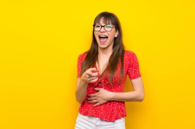 Üzerinde sarı duvar çok gülümseyen genç kadın