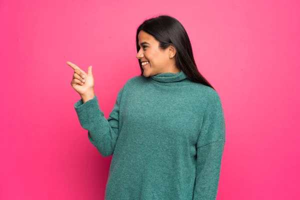 Joven Colombiana Con Suéter Verde Apuntando Con Dedo Hacia Lado — Foto de Stock