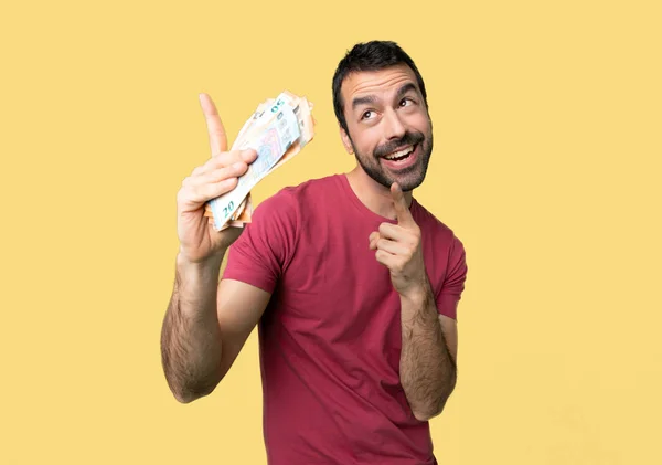 Man Taking Lot Money Pointing Index Finger Looking Isolated Yellow — Stock Photo, Image