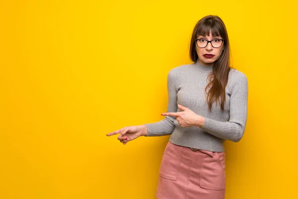 Mujer Con Gafas Sobre Pared Amarilla Asustada Apuntando Hacia Lado — Foto de Stock