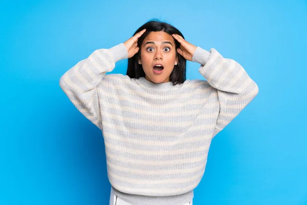 Young Colombian girl with sweater with surprise and shocked facial expression