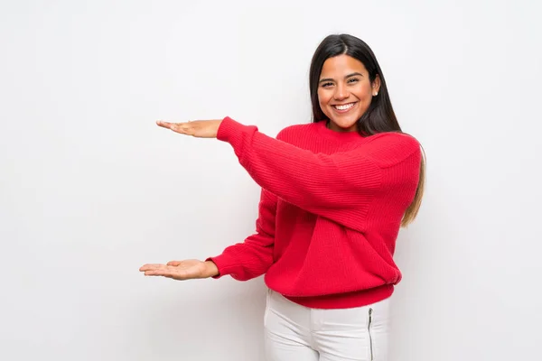 年轻的哥伦比亚女孩与红色毛衣举行复制空间插入广告 — 图库照片