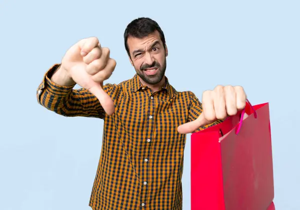 Man Met Boodschappentassen Tonen Duim Naar Beneden Met Beide Handen — Stockfoto