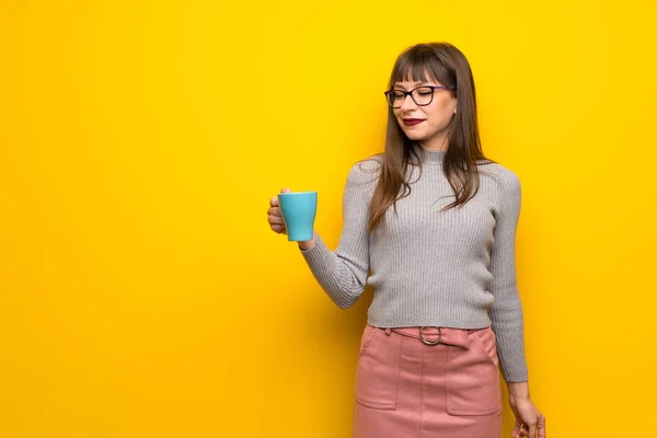 Žena Brýlemi Nad Žluté Zdi Drží Horký Šálek Kávy — Stock fotografie
