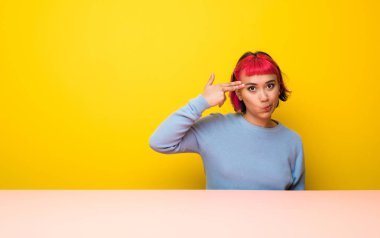 İntihar jest yapma sorunları olan pembe saçlı genç kadın