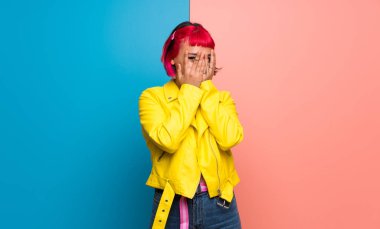 Sarı gözleri eller tarafından kapsayan ve parmaklarının arasından seyir ceket Bayan