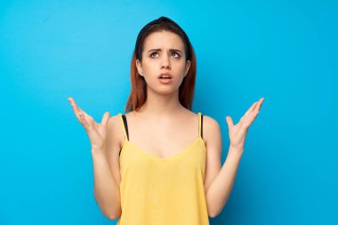 Mavi arka plan tarafından kötü bir durum hayal kırıklığına uğramış genç Kızıl saçlı kadın