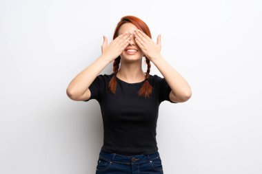 Beyaz duvar eller tarafından gözleri kaplama genç Kızıl saçlı kadın. İleride ne olduğunu görmek için sürpriz