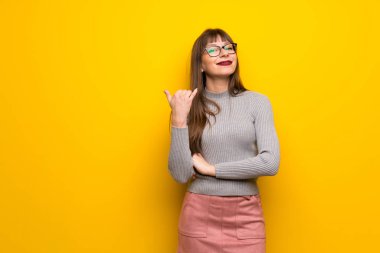 Telefon jest yaparak sarı duvarın üzerinden gözlüklü kadın. Bana arka işareti de