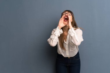 Mavi duvar üzerinde gözlük ile kadın çığlık ve bir şey duyurulması