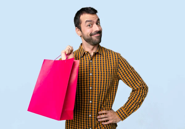 Człowiek Torby Zakupy Stwarzające Bronią Biodrze Śmiechem Patrząc Przód Białym — Zdjęcie stockowe