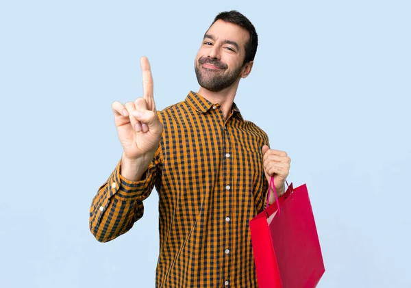 Mann Mit Einkaufstaschen Zeigt Und Hebt Einen Finger Zeichen Des — Stockfoto