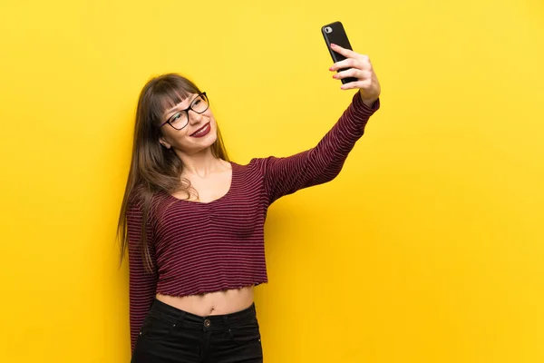 Γυναίκα Γυαλιά Πάνω Από Κίτρινο Τοίχο Φτιάχνοντας Μια Selfie — Φωτογραφία Αρχείου