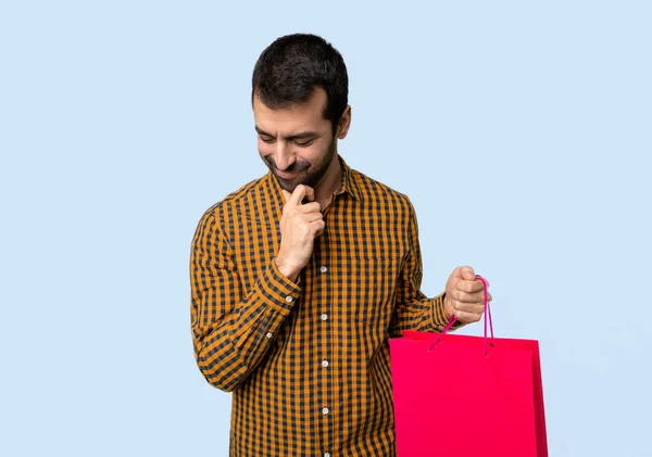 Man Shopping Bags Looking Hand Chin Isolated Blue Background — Stock Photo, Image