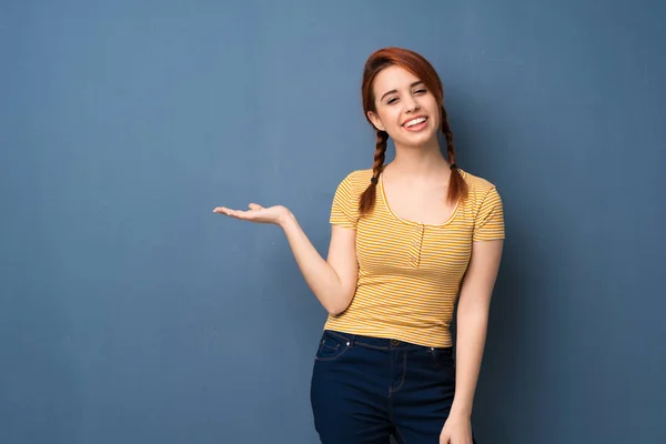 Joven Pelirroja Sobre Fondo Azul Sosteniendo Espacio Copia Imaginario Palma — Foto de Stock