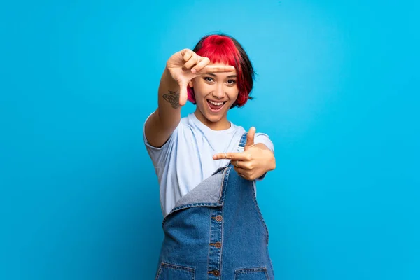 Mujer Joven Con Pelo Rosa Sobre Pared Azul Enfocando Cara —  Fotos de Stock