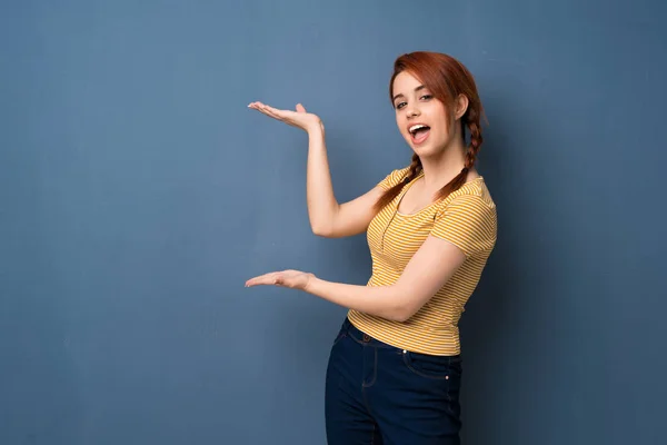 Joven Pelirroja Sobre Fondo Azul Extendiendo Las Manos Lado Para — Foto de Stock