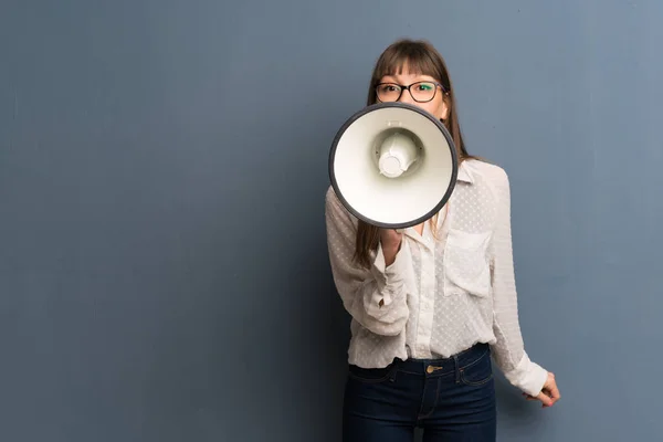 Vrouw Met Bril Blauwe Muur Schreeuwen Door Een Megafoon Kondigen — Stockfoto