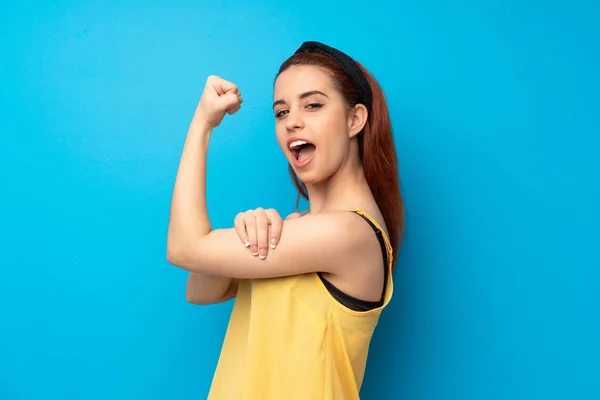 Giovane Rossa Donna Sfondo Blu Facendo Gesto Forte — Foto Stock