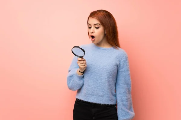 Jonge Roodharige Vrouw Roze Achtergrond Houdt Een Vergrootglas — Stockfoto