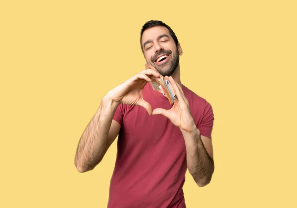 Man Taking Lot Money Making Heart Symbol Hands Isolated Yellow — Stock Photo, Image