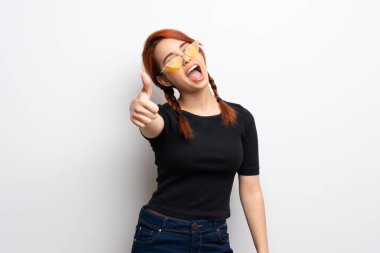 Beyaz genç Kızıl saçlı kadın duvar ile başparmak çünkü iyi bir şey oldu