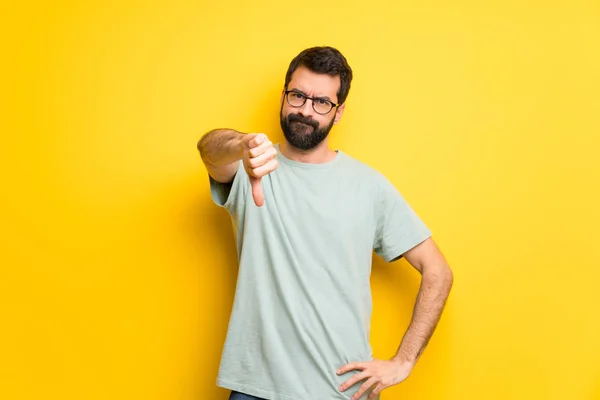 Muž Vousy Zelené Tričko Ukazuje Palec Dolů Cedulka Negativní Výraz — Stock fotografie