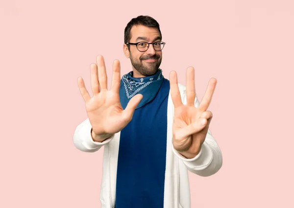Przystojny Mężczyzna Okularami Licząc Osiem Palcami Białym Tle Różowy — Zdjęcie stockowe