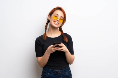 Beyaz Duvar mobil ileti gönderme genç Kızıl saçlı kadın