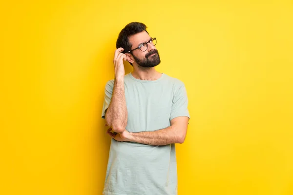 Homem Com Barba Camisa Verde Tendo Dúvidas Enquanto Coça Cabeça — Fotografia de Stock