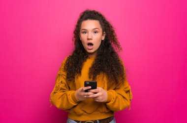 Genç kız şaşırttı ve ileti gönderme pembe duvar üzerinde