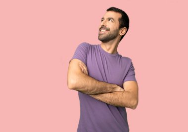 İzole pembe arka planda gülümsüyor iken yakışıklı adam bakıyor