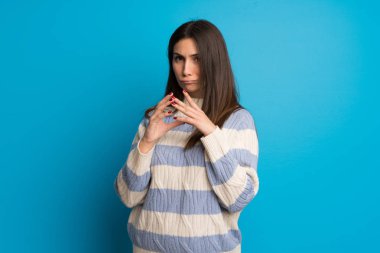 Mavi duvar üzerinde genç kadın bir şey ententleme