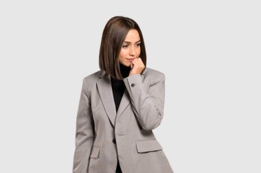 İzole gri arka plan üzerine şüpheleri genç iş kadını