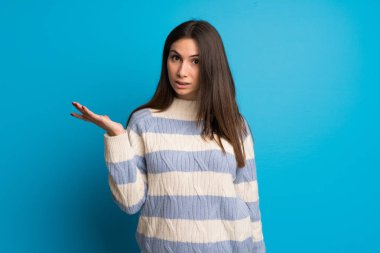 Mavi duvar önemsiz jest yapma genç kadın