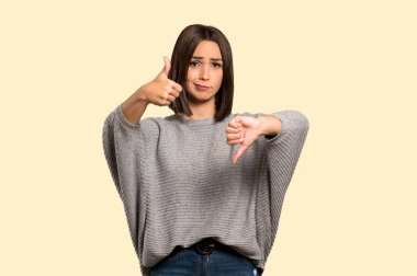 Genç kadın iyi-kötü işaret yapma. Kararsız Evet arasında veya izole Sarı zemin üzerinde değil