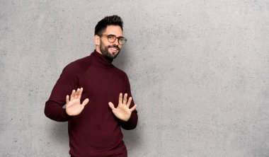 Gözlüklü dokulu duvar'ın üstüne gülümseyen yakışıklı adam