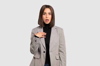 Genç iş kadını şaşırttı ve gri arka plan izole sağ seyir ederken şok