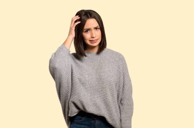 Genç kadın izole Sarı zemin üzerine şüpheleri