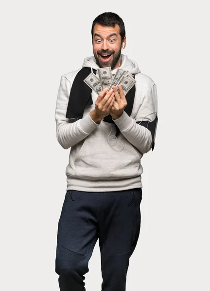 Sport man taking a lot of money over isolated grey background