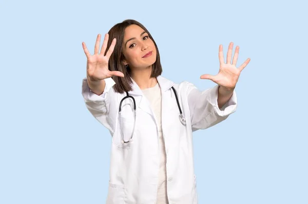 Joven Doctora Contando Diez Con Dedos Sobre Fondo Azul Aislado — Foto de Stock