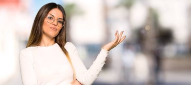 Eller açık havada gelmek davet için tarafa uzanan gözlüklü güzel kadın