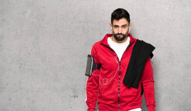 Dokulu duvar üzerinde üzgün ve depresyonda ifade ile yakışıklı sportman