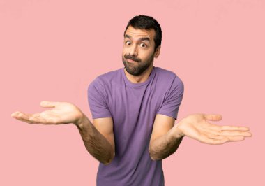 İzole pembe arka planda eller ve omuzlar yetiştirirken şüpheleri olan yakışıklı adam