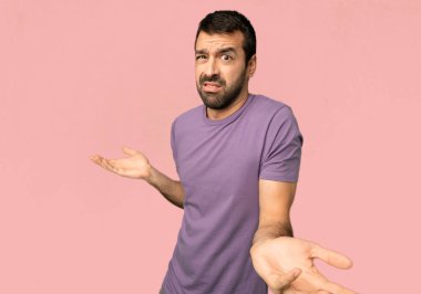 Yakışıklı adam mutsuz ve bir şey ile sinirli çünkü izole pembe arka planda bir şey anlamıyorum